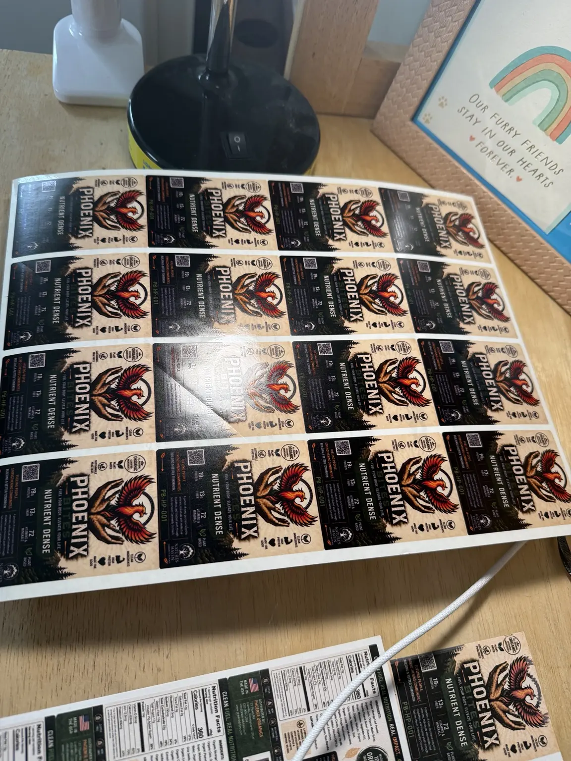 Sheets of early Phoenix Bites labels on a work table